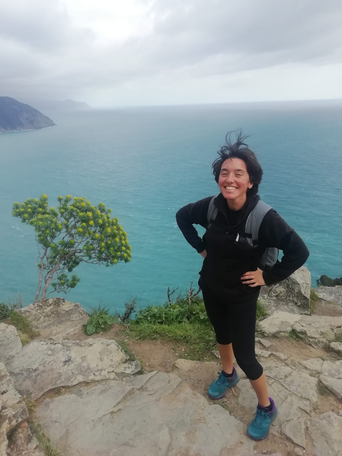 Picture showing Laura on top of a cliff with messy hair, learning to be comfortable feeling silly
